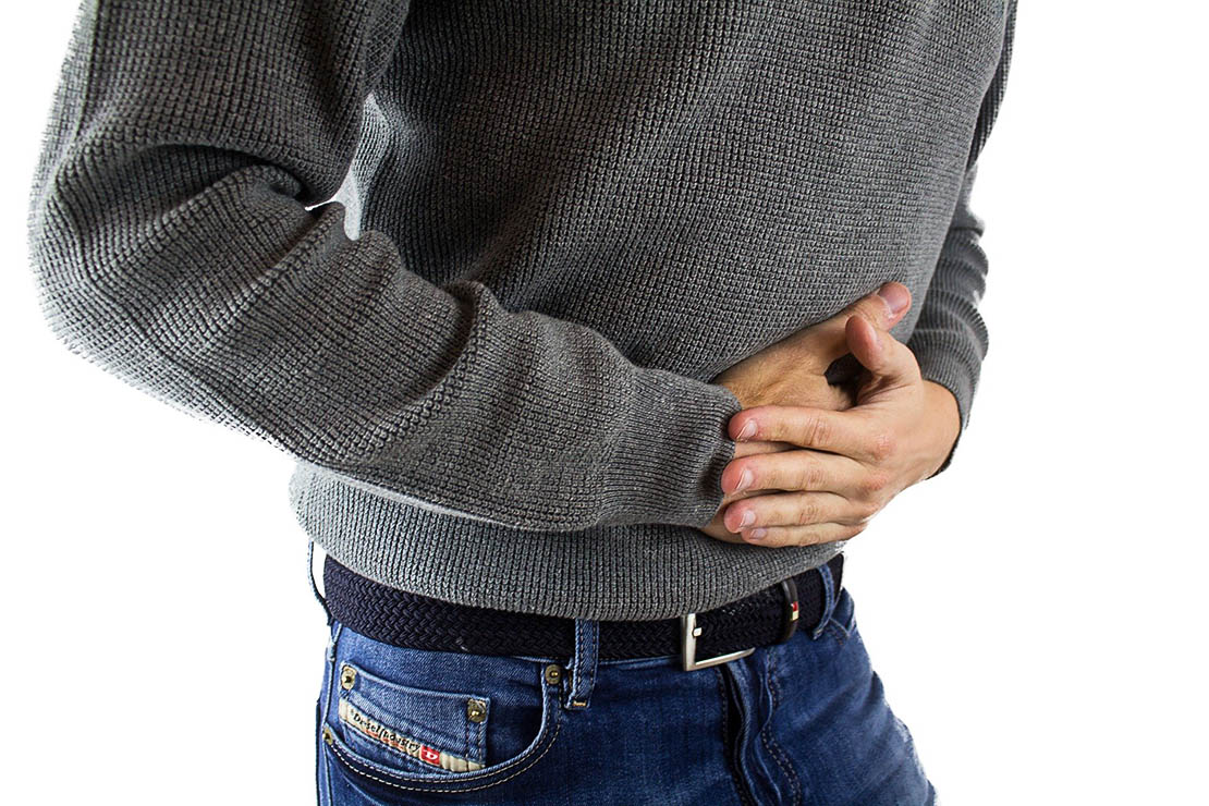 Person holding stomach to represent abdominal pain