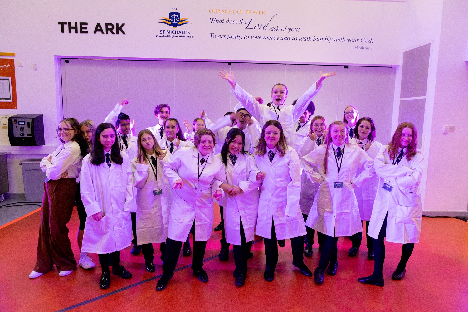Group of students in white lab coats in school hall