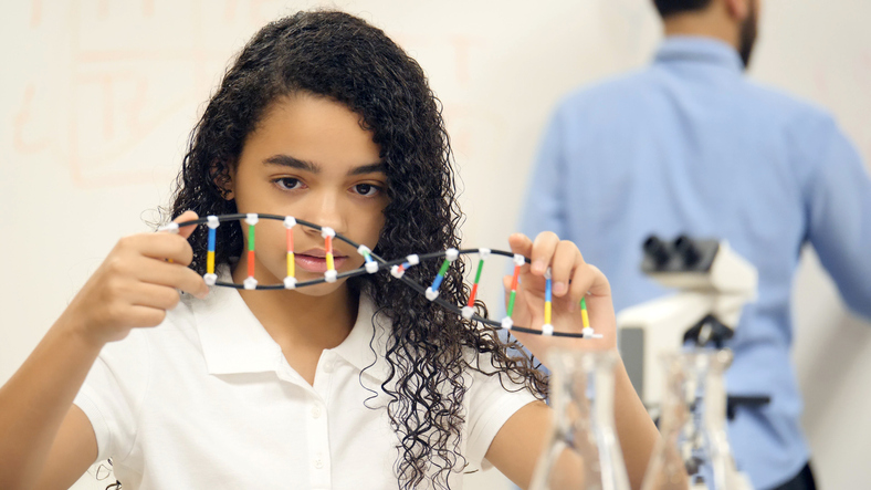Girl holding up a DNA strand Girl holding up a DNA strand