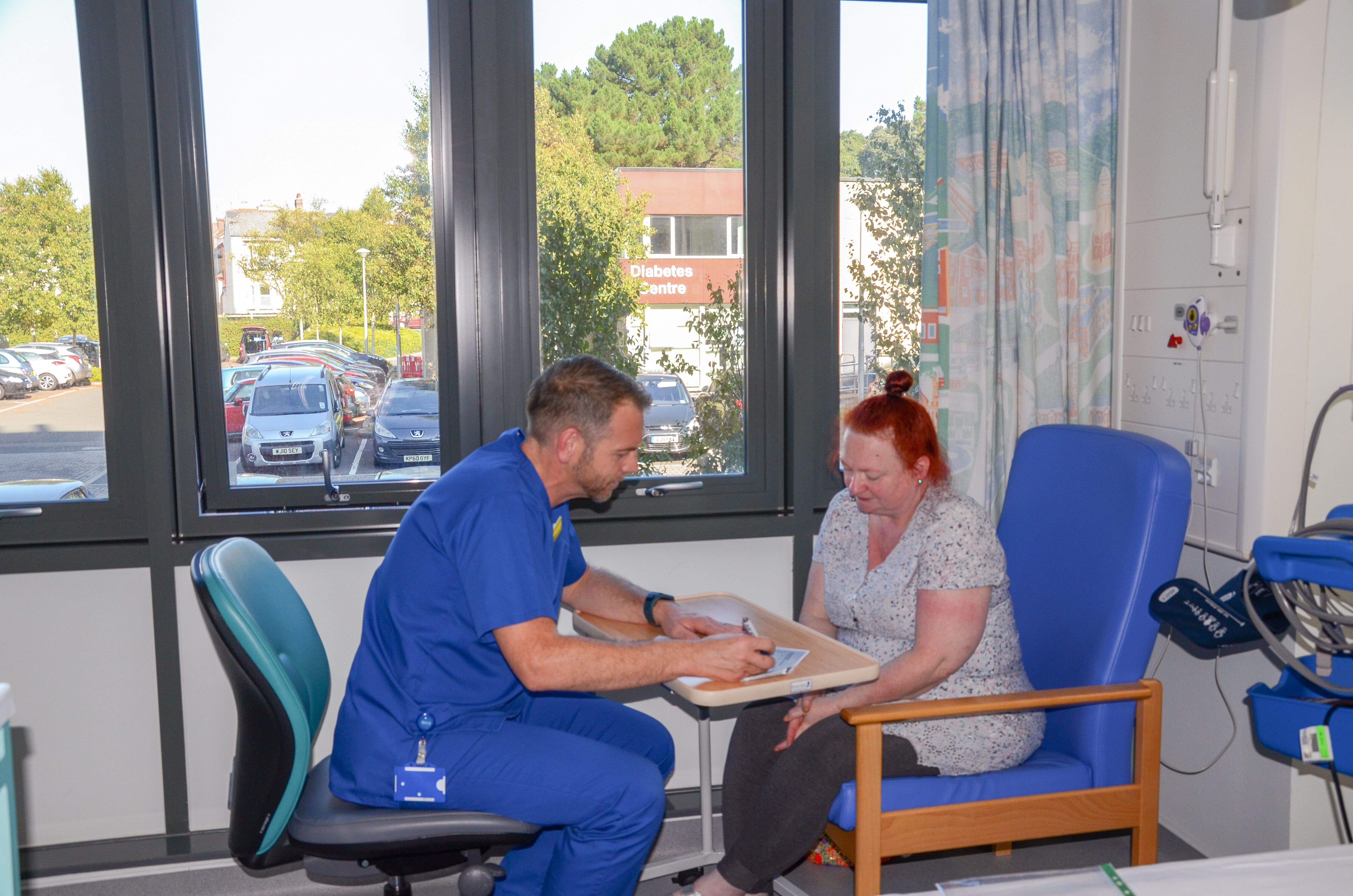photo of: patient with clinician signing/filling out consent form