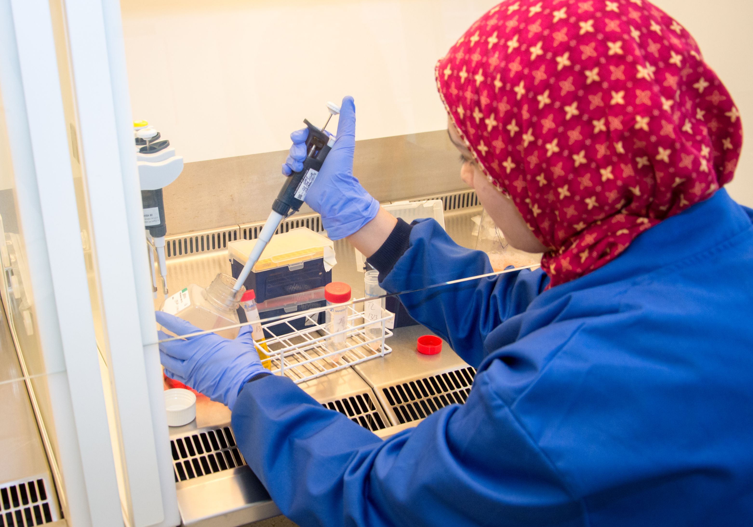 photo of: clinician in laboratory with test tubes