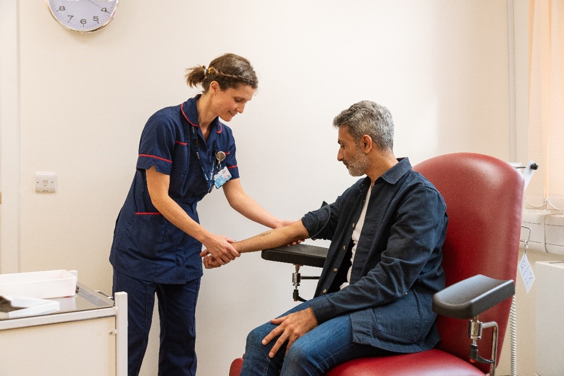 Nurse holding patient's arm in hospital room