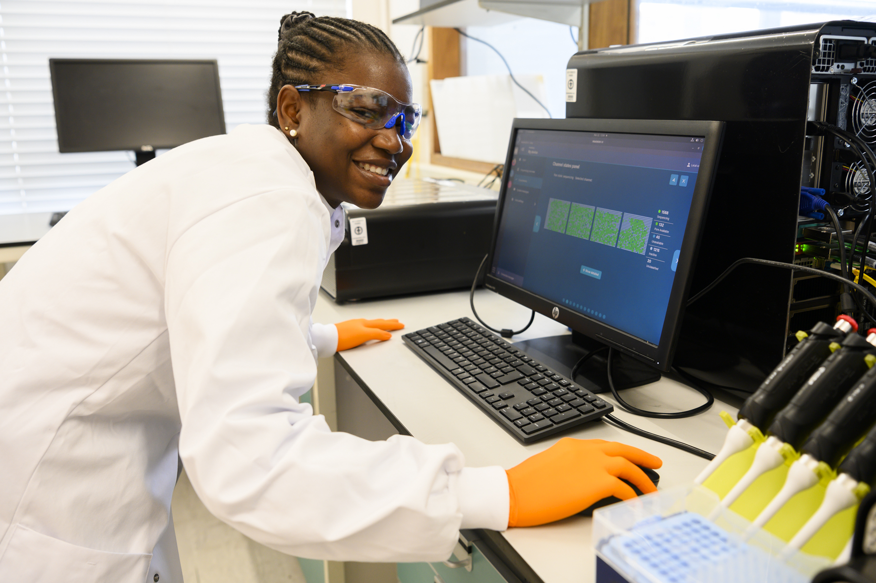 Member of staff in lab using computer Member of staff in lab using computer