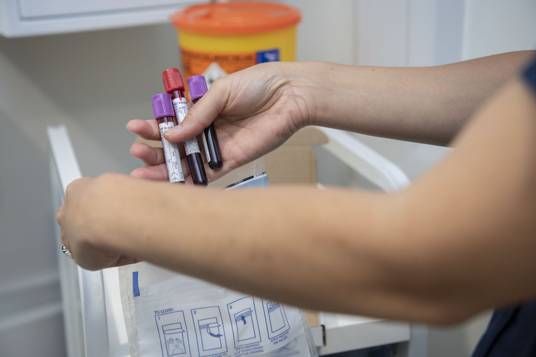 Blood samples in test tubes being placed into a biosample bag Blood samples in test tubes being placed into a biosample bag