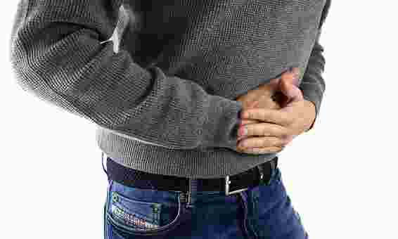 Person holding stomach to represent abdominal pain