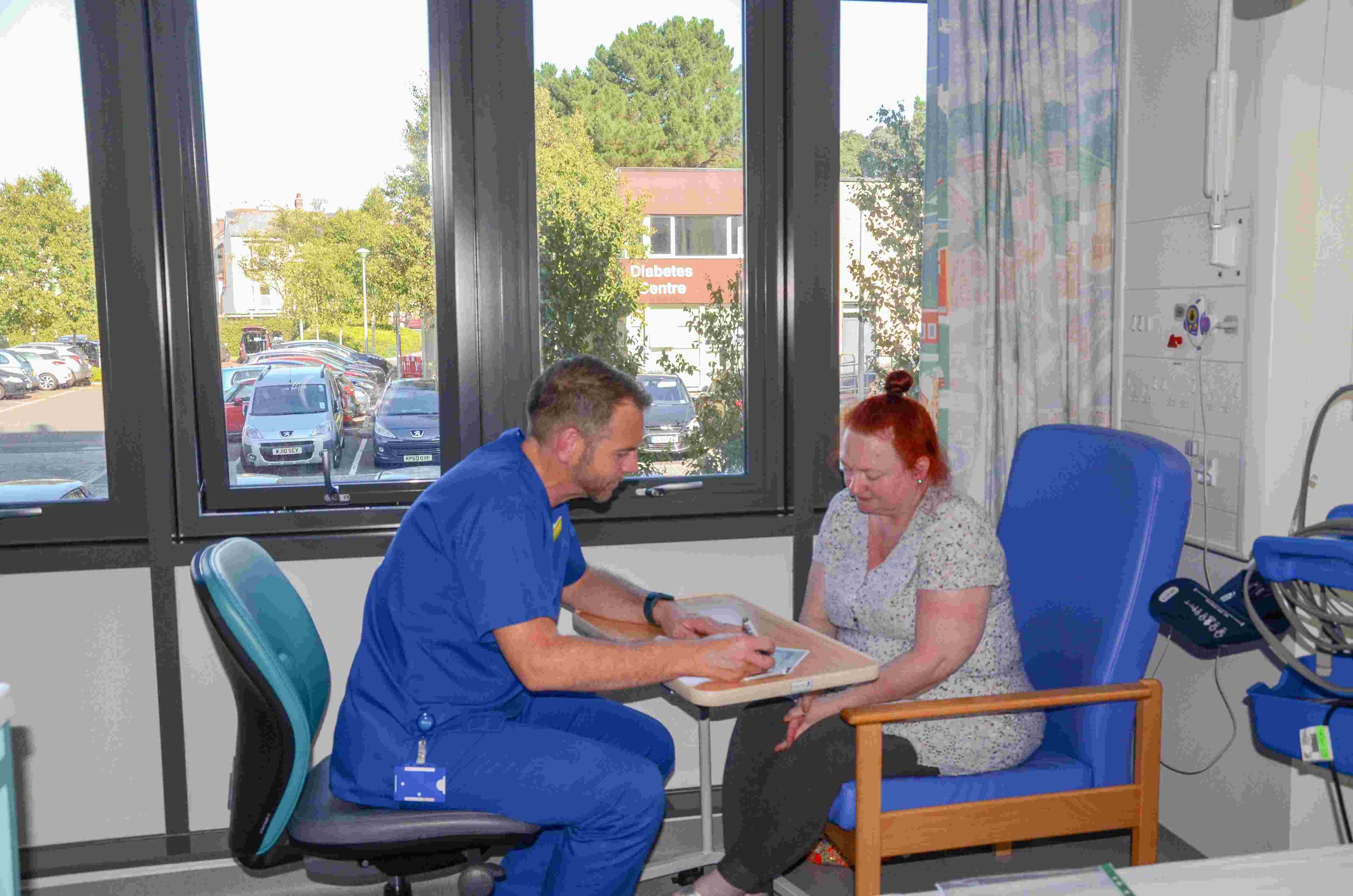 photo of: patient with clinician signing/filling out consent form