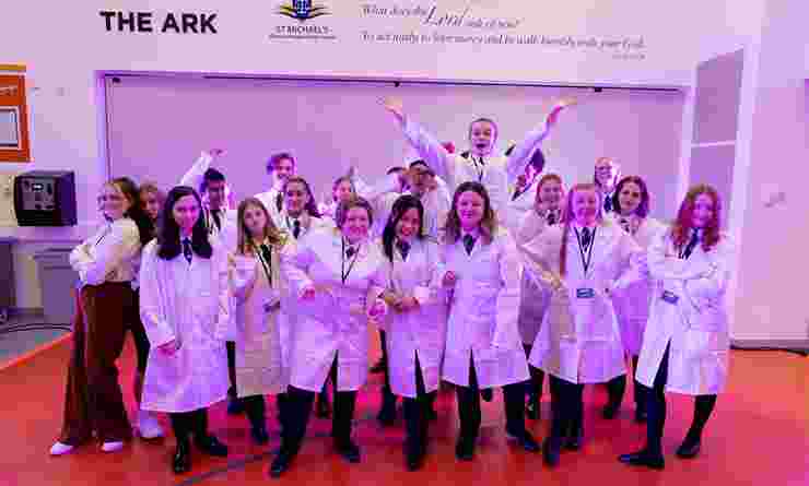 Group of students in white lab coats in school hall