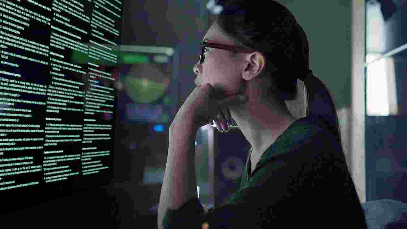 Woman reads computer screen in darkened lab